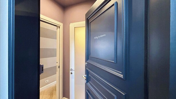 Un couloir avec une porte fermée sur laquelle est inscrit « Appartements de vacances ».