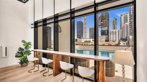 Un intérieur moderne avec vue sur la piscine, un long bar et une plante en pot.