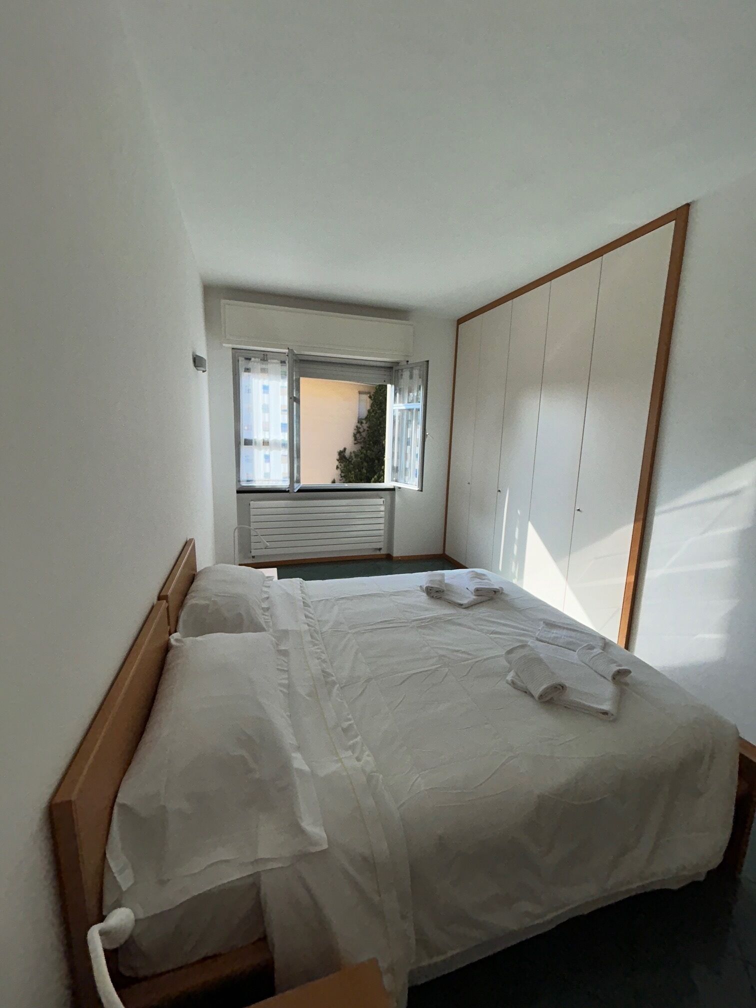 Quarto com cama, janela e guarda-roupa.