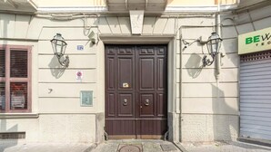 A building with a dark brown double door, a sign with 'BEW TECH' on the right, and a 'PASSO CARRABILE' sign on the left. - Luxury Apartment for 5 with Terrace in Chiaia (Napoli)