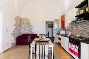 Una cocina moderna con comedor, un sofá rojo y una pared de acento de piedra.