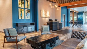 A modern interior with a sofa, armchairs, a coffee table, and a dining area with a bicycle.