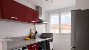 Eine kompakte Küche mit Waschmaschine, Herd und Kühlschrank.