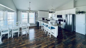A kitchen with white cabinets, a stainless steel refrigerator, a microwave, and a ceiling fan. - Surf City Ocean View - 4-min Walk to Beach - Walk to Restaurants/Bars (Surf City)