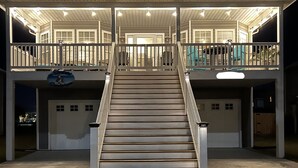 A two-story building with a central staircase, multiple garage doors, and a covered front porch. - Surf City Ocean View - 4-min Walk to Beach - Walk to Restaurants/Bars (Surf City)