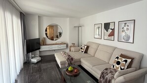A modern living room with a sofa, coffee table, and artwork on the walls. - Center Park Apartment (Interlaken)