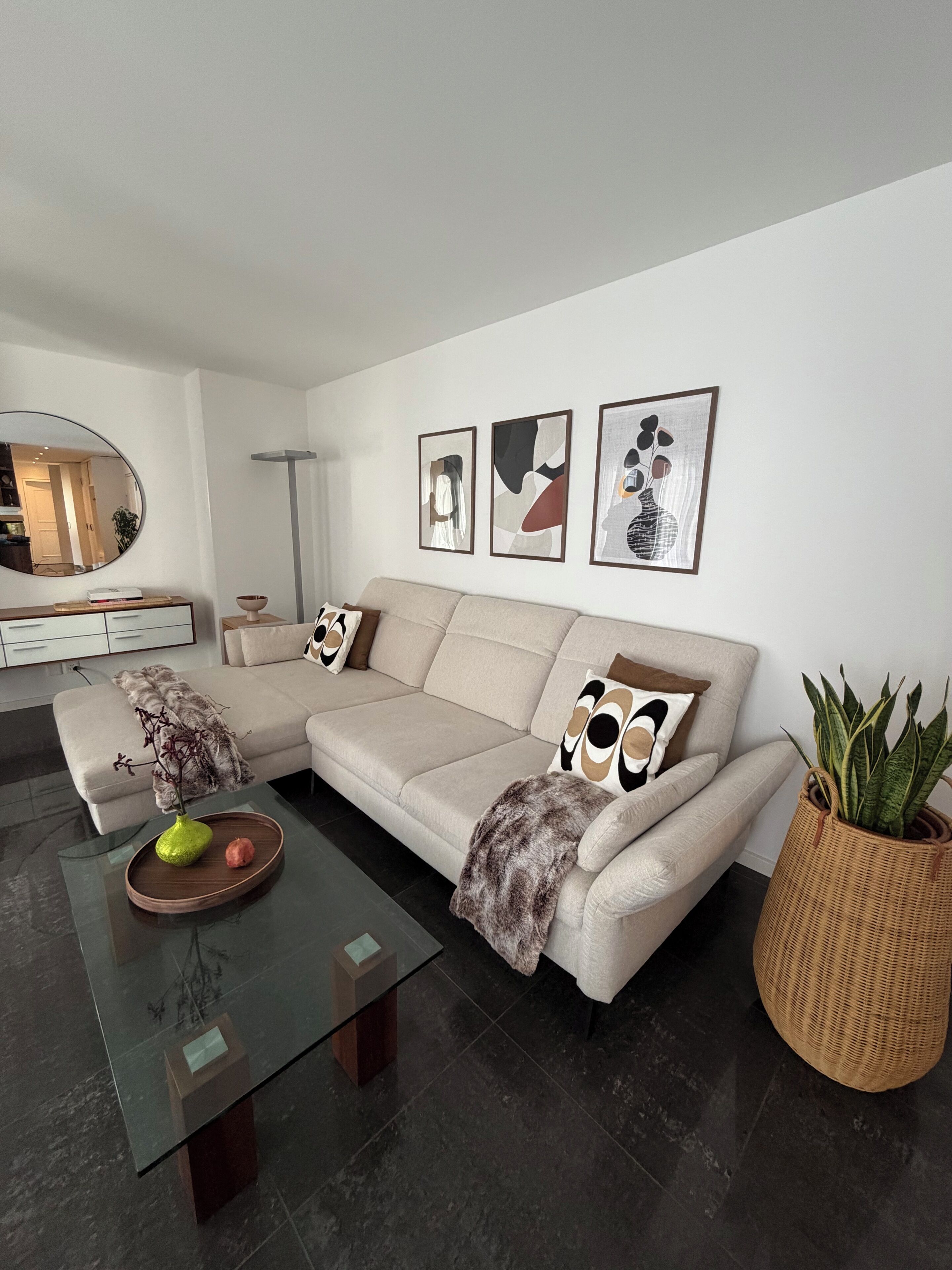 Una sala de estar moderna con un sofá, una mesa de centro y elementos decorativos.