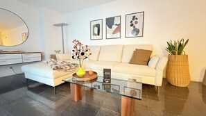 A modern living room with a sofa, coffee table, and decorative items. - Center Park Apartment (Interlaken)