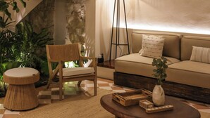 A cozy living room with a sofa, a round coffee table, a chair, and a floor lamp.
