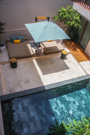 An infinity pool with a seating area, a table with an umbrella, and potted plants. - Casa Emma Santa Marta by Xarm Apartments (Santa Marta)