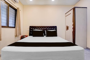 A hotel room with a bed, a wardrobe, a window with curtains, and a telephone on the nightstand. - Townhouse Oak Phaltan Shivjal City (Phaltan)