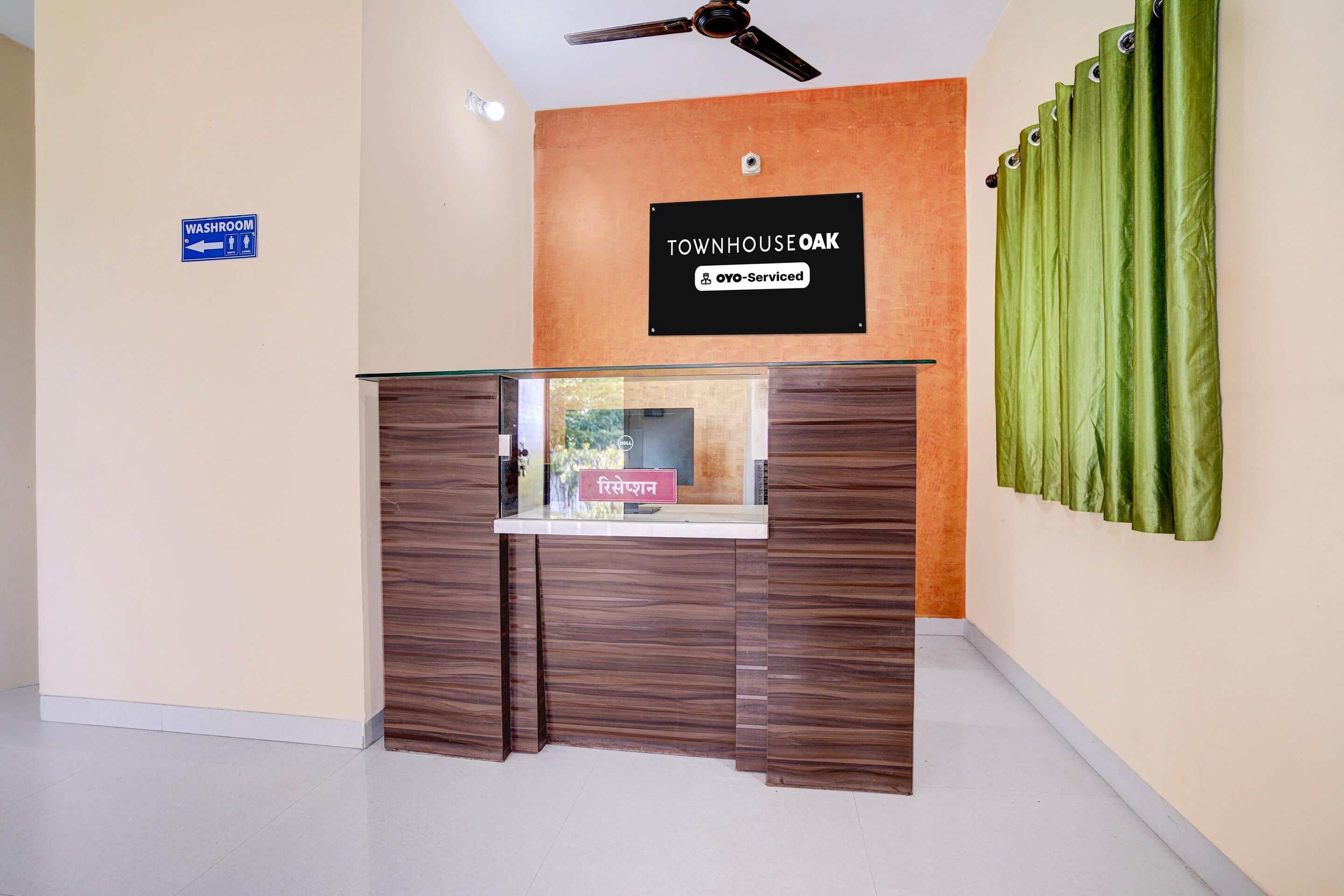 A reception desk with a sign indicating a washroom to the left.