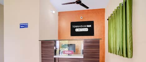 A reception desk with a sign indicating a washroom to the left.