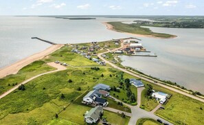 Eine Luftaufnahme einer Küstenortschaft mit Häusern, Straßen und einem Strand.
