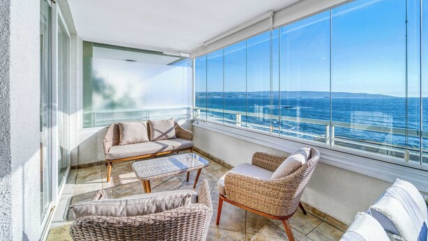 A balcony with a view of the sea, furnished with wicker chairs and a sofa. - Pacific Terrace - Vista al mar- 4 huéspedes - Wifi (Viña del Mar)