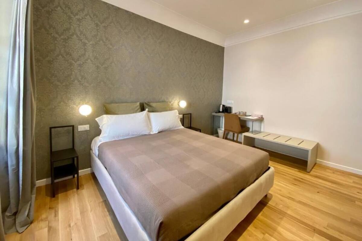 Ein Schlafzimmer mit einem Bett, Nachttischen, einem Schreibtisch und einer Bank.