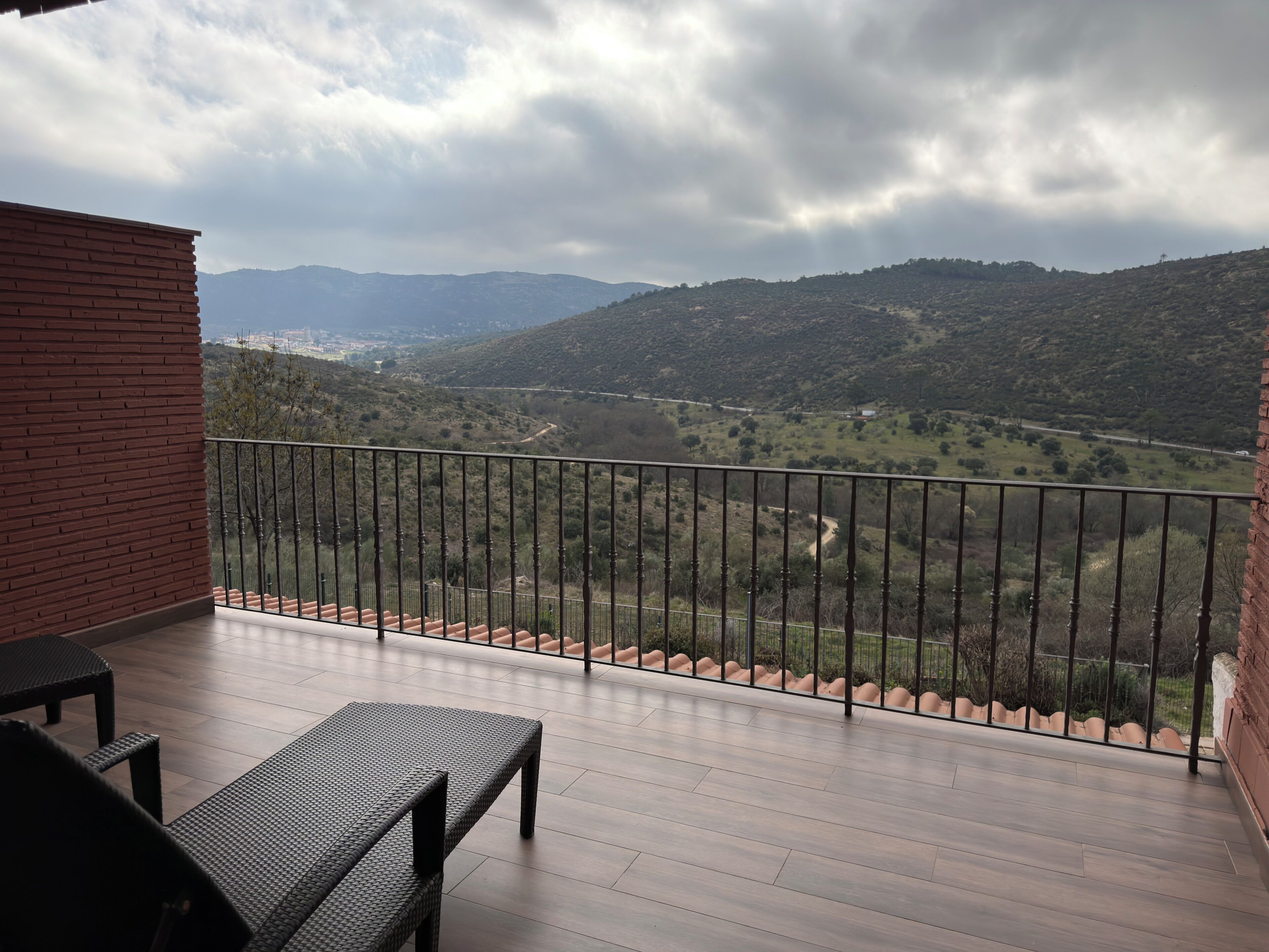 Un balcon donnant sur une vallée et des montagnes.