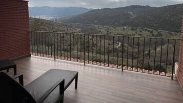 Un balcon donnant sur une vallée et des montagnes.