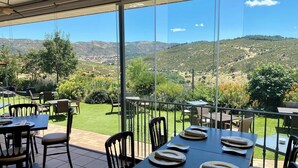 Terraza con mesas dispuestas para comer, con vistas a un paisaje pintoresco.