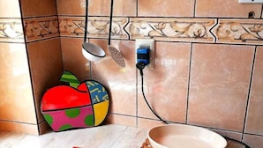A kitchen with a tiled backsplash, a wooden shelf, a colorful bowl, a white bowl, and a pet food bowl. - Bello departamento en la Maravillosa ciudad de La Paz (La Paz)