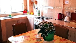 A kitchen with a gas stove, a sink, a stove top oven, a refrigerator, and a dining table with chairs. - Bello departamento en la Maravillosa ciudad de La Paz (La Paz)