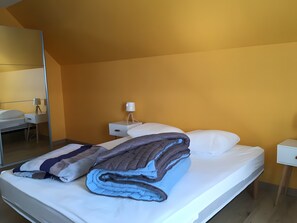 Une chambre d’hôtel avec un lit, une table de chevet, une lampe et un miroir.