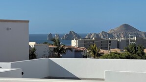 Küstliche Ansicht mit Gebäuden, einem Berg und dem Meer.