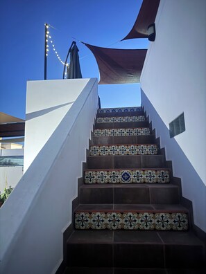 A staircase with patterned tiles, a white wall, and a dark awning. - SPECTACULAR 4-BR Villa w ARCH Vws, Pool,BBQ, Breakfast. Av-Tqla tasting,Spa&Chef (Cabo San Lucas)