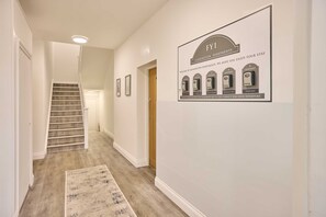 A hallway with a staircase, a rug, and a sign indicating FY1 apartments. - Host Stay Illumination Suite (Blackpool)