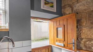 Une salle de bain avec un meuble en bois, un lavabo et une fenêtre donnant sur une route.