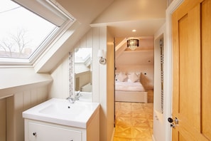 A bedroom with a skylight, a chandelier, and a wooden door. - Host Stay Osbourne Apartment (Newcastle-upon-Tyne)