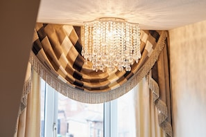 A chandelier with hanging crystals above a window with curtains. - Host Stay Osbourne Apartment (Newcastle-upon-Tyne)