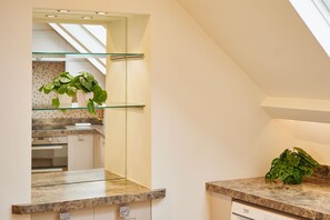 A modern kitchen with a glass shelf, a built-in oven, and a countertop. - Host Stay Osbourne Apartment (Newcastle-upon-Tyne)