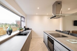 Una cocina moderna con un amplio ventanal, horno empotrado y una encimera elegante.