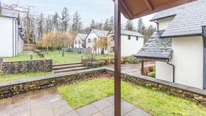 A residential area with stone walls, a grassy lawn, and houses with sloped roofs. - Host Stay 11 Troutbeck (Penrith)
