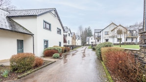 A residential street with houses, a paved road, and a stone wall. - Host Stay 11 Troutbeck (Penrith)