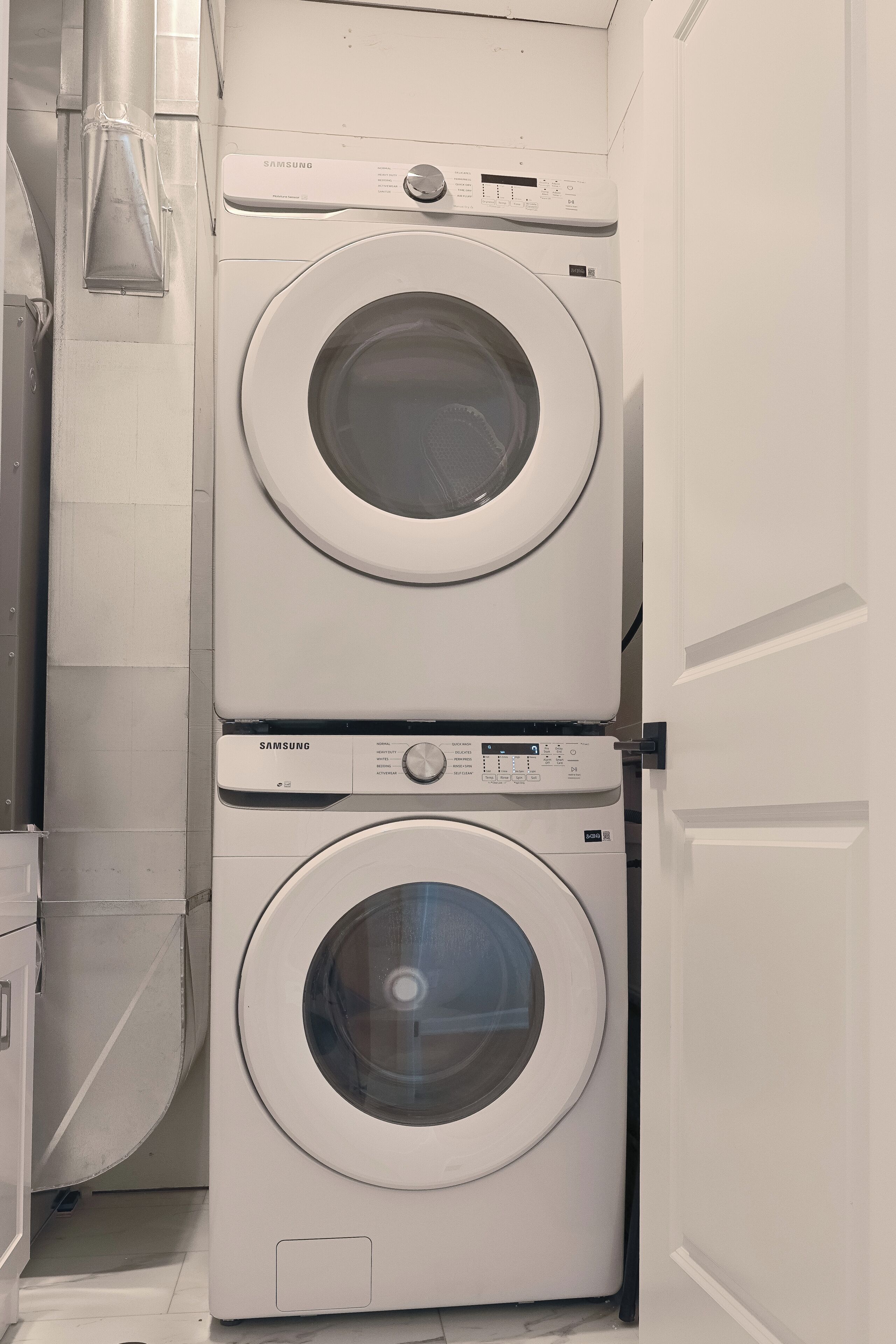A stacked washer and dryer unit in a laundry room.