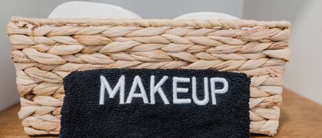 A woven basket with a black cloth labeled 'MAKEUP' on a wooden surface.