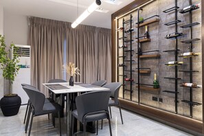 Ein moderner Essbereich mit Tisch, Stühlen und einem Weinkühlschrank an der Wand.