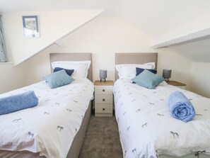 A twin room with two beds, each with a headboard, bedside tables, and lamps. - Yewbarrow (Seascale)