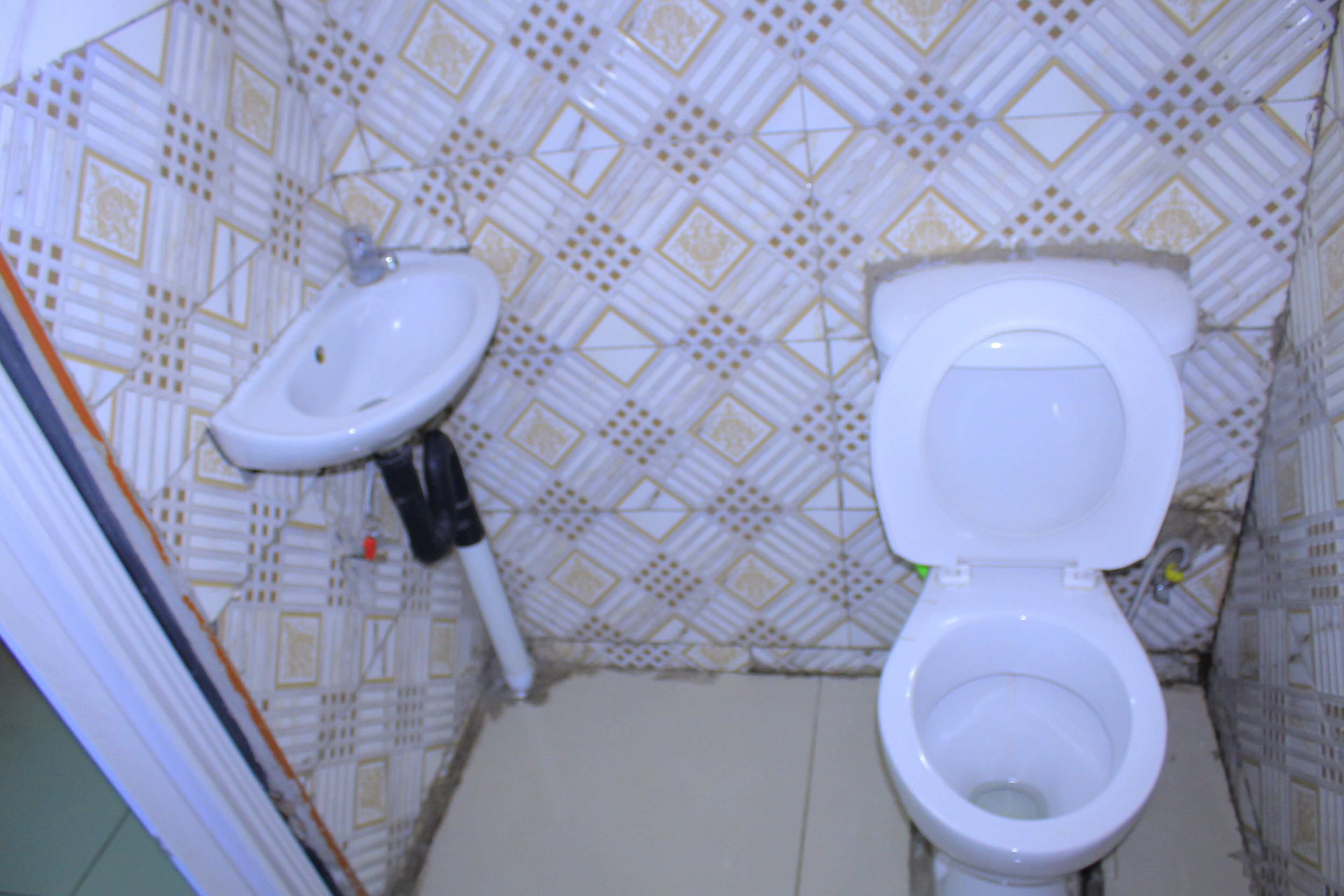 Un baño con inodoro, lavamanos y paredes con diseño.