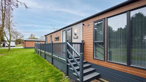 Un bâtiment moderne avec une façade en bois, de grandes fenêtres et un escalier menant à une terrasse.