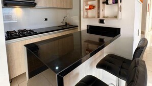 Une cuisine moderne dotée d’un îlot central, d’un four à micro-ondes encastré et d’un meuble à vin.