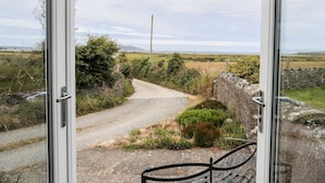 A rural landscape with a gravel path, stone walls, and greenery. - Bodlasan Groes Cottage (Holyhead)