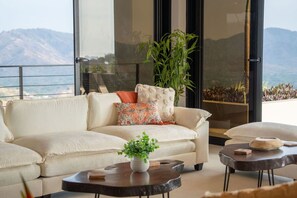 A modern living room with a sofa, a coffee table, and a plant. - NEW! Oceanview, Infinity Pool, Spacious & Private Luxury Group Retreat (Potrero)