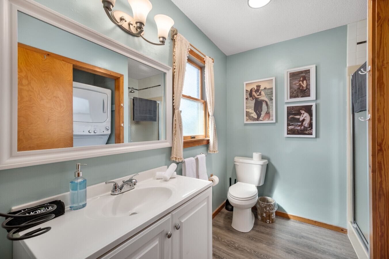A bathroom with a white sink, a toilet, and a mirror.