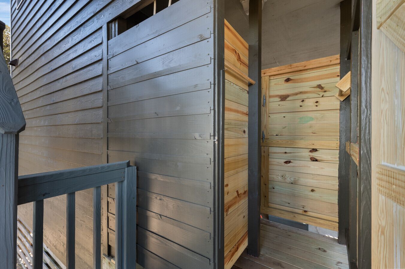A wooden exterior with a metal gate and a wooden door.