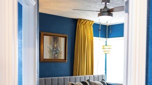A bedroom with a bed, a ceiling fan, a window with curtains, and a framed picture on the wall. - 3-Bedroom house in tree-lined neighborhood in Millcreek (Salt Lake City)