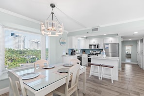 A modern kitchen with a dining area, large windows, and a city view. - Beachside II #4247 (Miramar Beach)