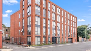A red brick building with multiple windows and a gated entrance. - Liverpool Richmond Row 2 Bed/2 Bath Flat (107)| Secure Parking, WiFi & EV (Liverpool)